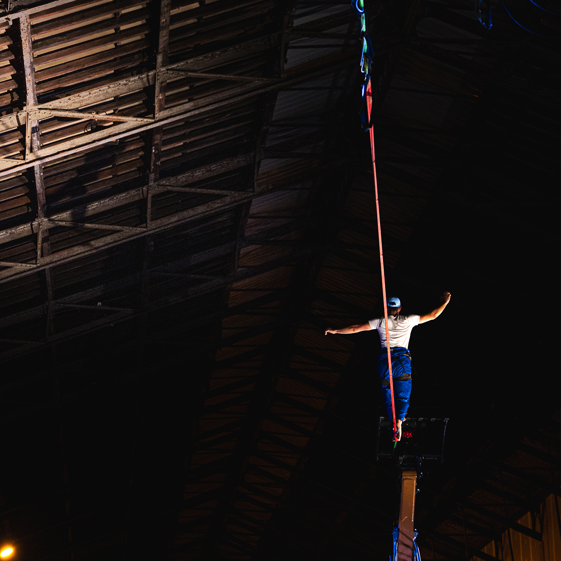 acrobate marchant sur un fil suspendu en intérieur