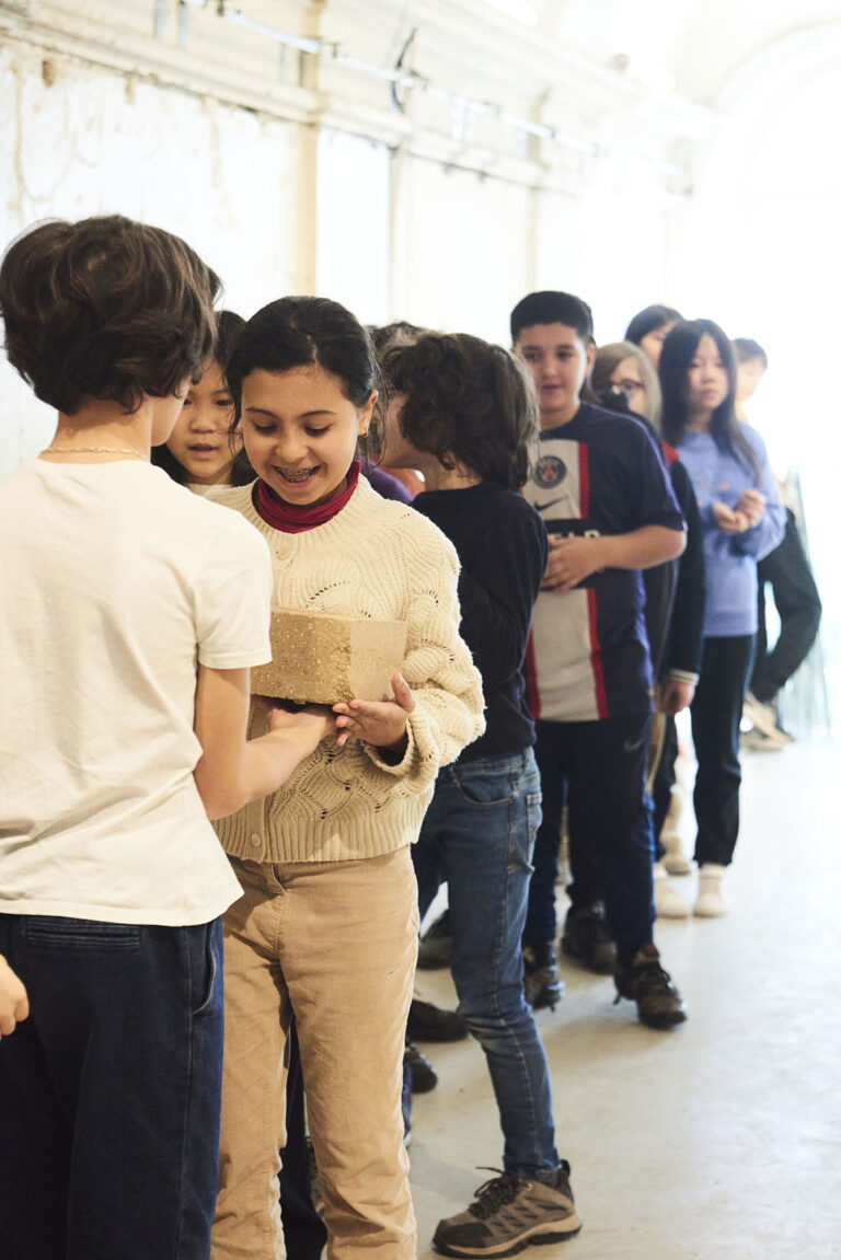 Enfants manipulant des blocs de terre crue